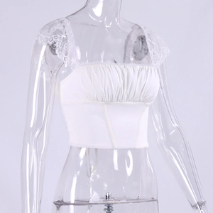 Detail van witte kanten crop top met vierkante hals en geplooide stof op de borst
