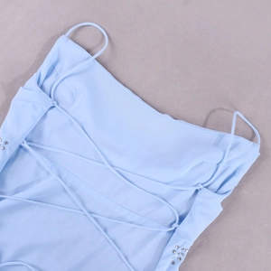 Détail de la robe en mousseline bleu clair avec laçage au dos et bordure en strass