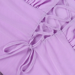 Dettaglio della vestaglia in tulle viola chiaro con raffinato design ad intreccio e lacci