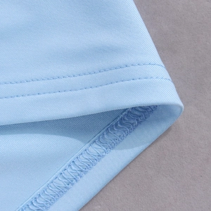 Détail de la double couture et des bords surjetés sur tissu en soie de lait bleu