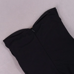 Close-up of the back invisible zipper and gold metal ring detail on a black mesh dress