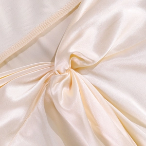 Detail of champagne satin dress showing twist knot design and ribbed fabric stitching