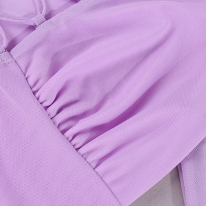 Dettaglio macro del tessuto a rete lavanda con texture plissettata e laccetto sul vestito
