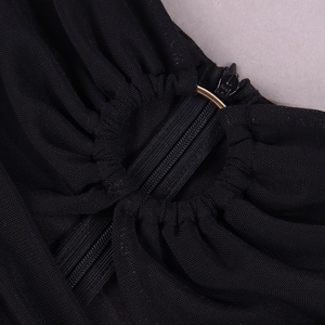 Detail of invisible zipper and golden metal ring on black pleated mesh dress