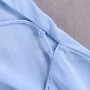 Détail de la robe en mousseline bleu clair avec cordon réglable et coutures de précision