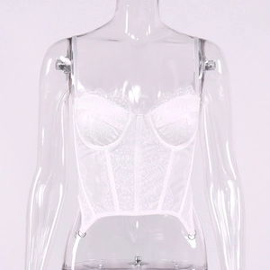 Dettaglio top a corsetto in pizzo bianco con ricami floreali e anello in metallo