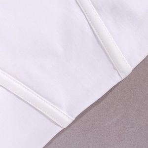 Detail van de witte kantentop met parallelle dubbele stiksels en verstevigende baleinen