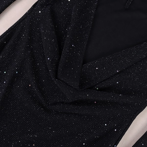 Detail of black V-neck overlapping bodice featuring shimmering mesh fabric and silver sequins