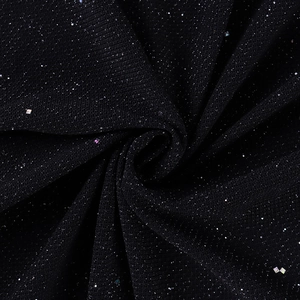Detailed macro shot of black mesh fabric with shimmering sequins and soft draped folds