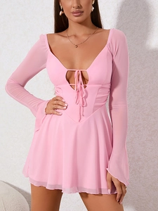 Detail of pink mini dress featuring sheer mesh sleeves and lace-up V-neckline design