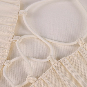 Dettagli di lacci incrociati e mesh a pieghe su un abito beige con scollo a V sexy