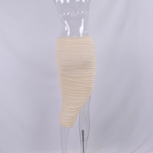 Détail de la jupe froncée en mesh beige avec ourlet asymétrique et tissu texturé