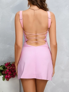 Dettaglio di un abito a rete rosa chiaro con schiena scoperta stringata e spalline sottili
