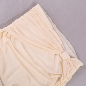 Détail du tissu en maille abricot avec des textures plissées et un ourlet élastique