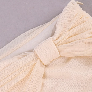 Détail du tissu en maille beige montrant la texture fine, le nœud élégant et le zip invisible