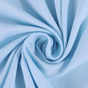 Détail macro du tissu en soie de lait bleu clair montrant une texture douce et élastique