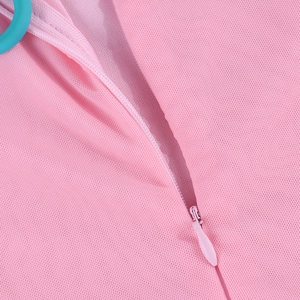 Detail of invisible zipper on light pink mesh dress with textured fabric close-up