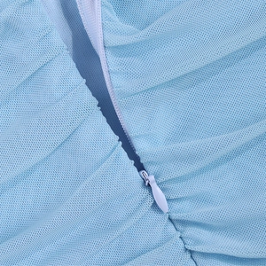 Macro view of high-quality invisible zipper on a light blue sheer mesh dress