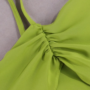 Detail of thin shoulder straps and ruffled chiffon fabric on a lime green summer dress
