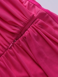Detail of rose red mesh dress featuring refined pleats and a matching invisible zipper