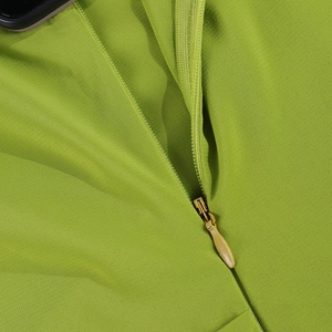 Close-up of the high-quality invisible metal zipper on a grass green chiffon dress