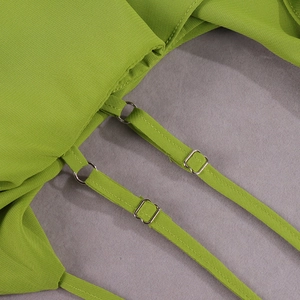 Detail of adjustable thin shoulder straps with silver metal buckles on a green chiffon dress