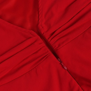 Detail of red dress featuring a V-neckline, invisible zipper, and fine pleated fabric