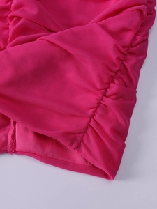 Detail of ruched mesh fabric in vibrant rose pink on the long sleeve party dress