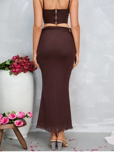Detail view of the brown two-piece set featuring a cropped top with gold back zipper and skirt