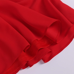 Detailed macro shot of red chiffon fabric showing precise rolled hem and pleated texture