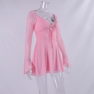 Detail of pink chiffon mini dress featuring deep V-neck, lace-up front, and bell sleeves