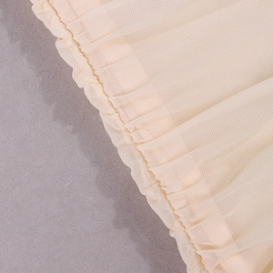 Gros plan détaillé du tissu en maille beige avec technique de fronces élastiques