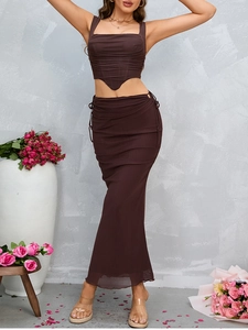 Detail of ruched dark brown skirt set showing side drawstring and sheer mesh texture