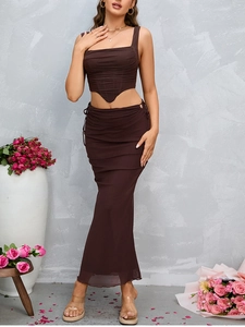 Detail of dark brown ruched fishtail maxi skirt and corseted crop top set for women