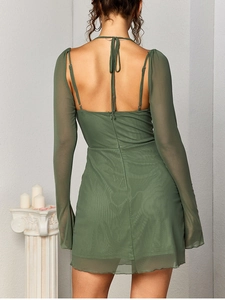 Detail of dark green mesh mini dress showing halter neck tie and elegant open back design