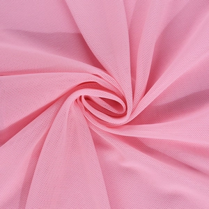 Detailed macro view of soft pink breathable mesh fabric with fine net texture and draping
