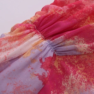 Makroaufnahme von Kleid mit abstraktem Aquarelldruck, gerafften Details und Naht