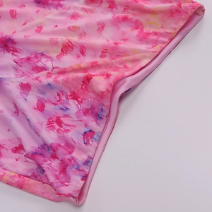 Detailed close-up of pink floral print fabric with fine stitching and elastic texture
