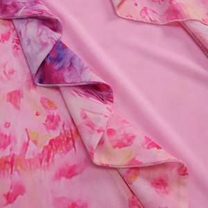Detailed close-up of pink mesh fabric with floral print and ruffle edge finish
