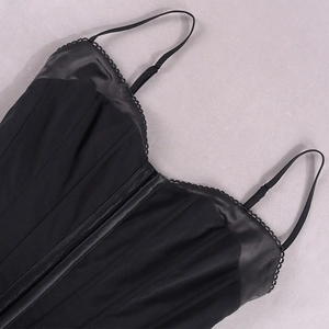 Detail eines schwarzen Korsett-Tops mit Satinsaum und Wellenkanten am Ausschnitt