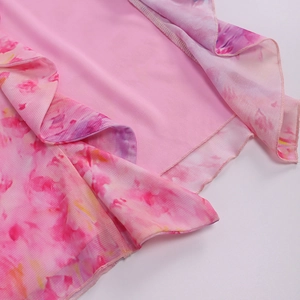 Detail of floral chiffon fabric with ruffled edges and refined overlock stitching