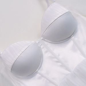 Detail view of white mesh dress bodice featuring structured corset boning and premium satin