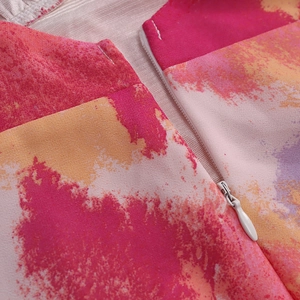 Detail view of colorful tie-dye mesh dress showing the invisible white zipper closure