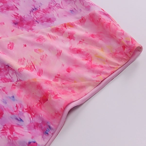Detailed macro view of pink purple watercolor tie-dye fabric and clean stitching seams