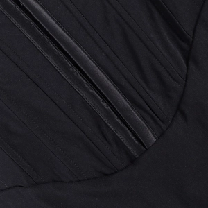 Makroaufnahme von vertikalen Stütznähten an einem schwarzen Mesh-Korsett-Kleid