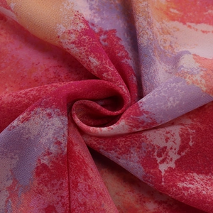 Detail aus weichem, leichtem Textil mit künstlerischem rotem und lila Aquarell-Blumendruck