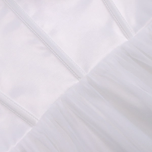 Detail showing the white satin bodice and pleated mesh waist seam of the dress