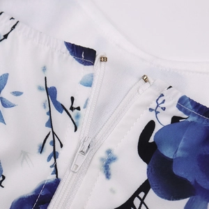 Detailed close-up of high-quality zipper and metal hook on blue floral dress fabric