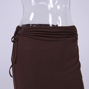 Detail of ruched deep brown knit skirt featuring side lace-up ties and stretchy texture