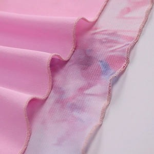 Macro detail of pink high-slit skirt featuring lettuce edge and layered mesh fabric